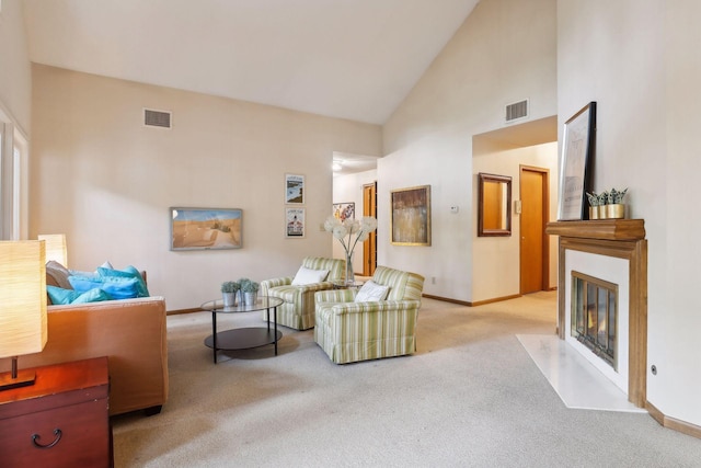 living area with light carpet and high vaulted ceiling