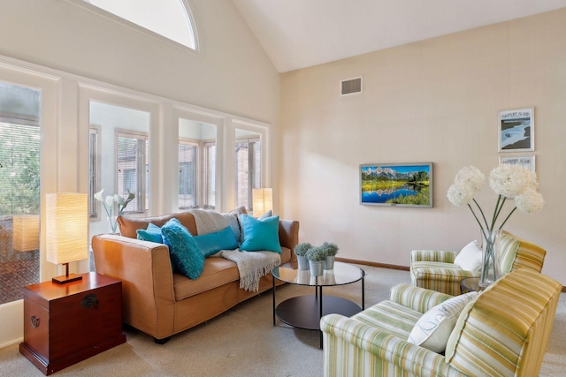 carpeted living room with high vaulted ceiling