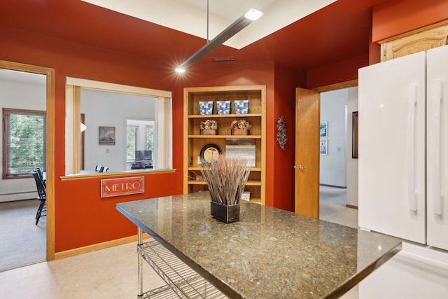 kitchen with light carpet, a baseboard heating unit, and a breakfast bar area