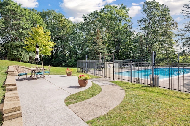 view of pool with a lawn and a patio