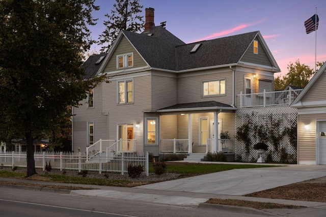 view of front of home with a porch, a balcony, and a garage