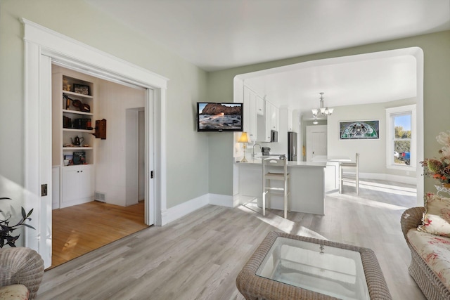 living room with light hardwood / wood-style flooring and a chandelier