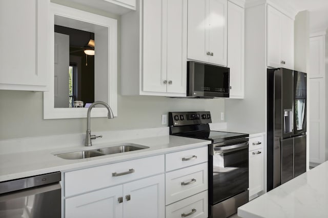 kitchen featuring sink, appliances with stainless steel finishes, light stone counters, and white cabinetry