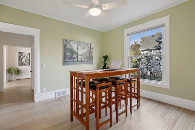 dining space featuring ornamental molding, light hardwood / wood-style flooring, and ceiling fan