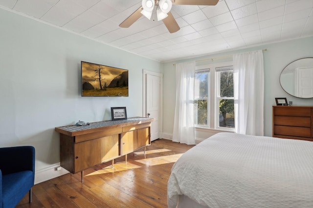 bedroom featuring ceiling fan, ornamental molding, and hardwood / wood-style floors