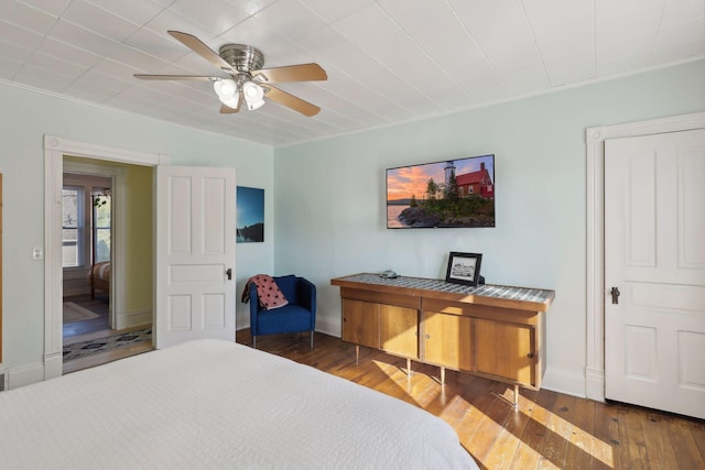 bedroom featuring crown molding, ceiling fan, and dark hardwood / wood-style flooring