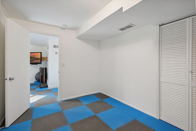 basement featuring dark colored carpet