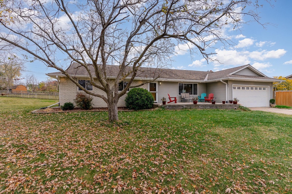 ranch-style house with a garage and a front lawn