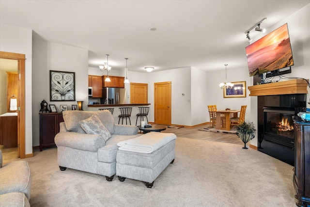 living room featuring a notable chandelier, light colored carpet, and rail lighting