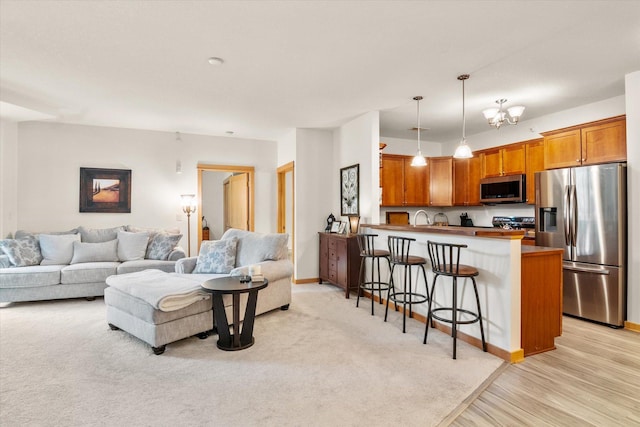 living room with light hardwood / wood-style floors, a notable chandelier, and sink