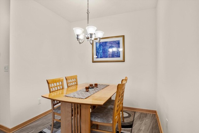 dining area featuring hardwood / wood-style flooring and a chandelier