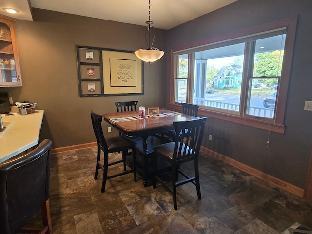 dining area featuring stone finish flooring and baseboards