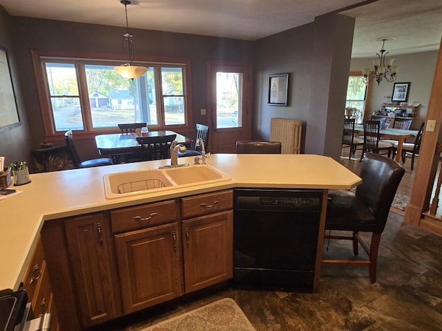 kitchen with a sink, a chandelier, pendant lighting, light countertops, and black dishwasher