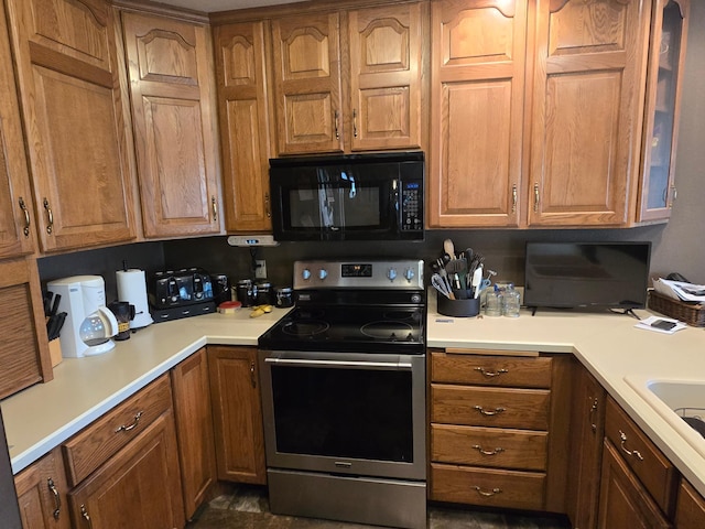 kitchen with light countertops, black microwave, stainless steel electric range oven, and brown cabinets