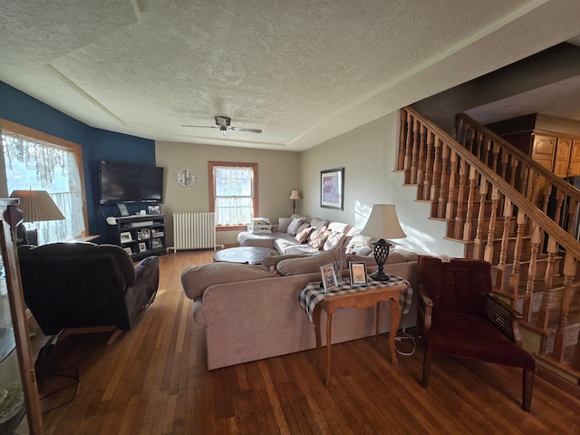 living area featuring radiator heating unit, a textured ceiling, stairway, and hardwood / wood-style floors