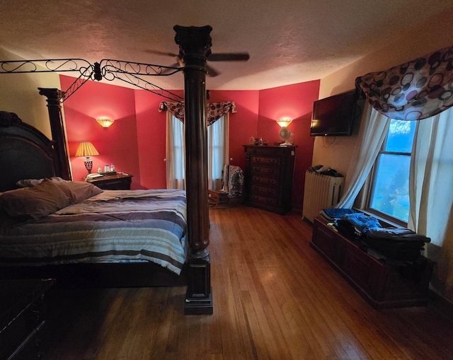 bedroom with radiator heating unit and hardwood / wood-style flooring
