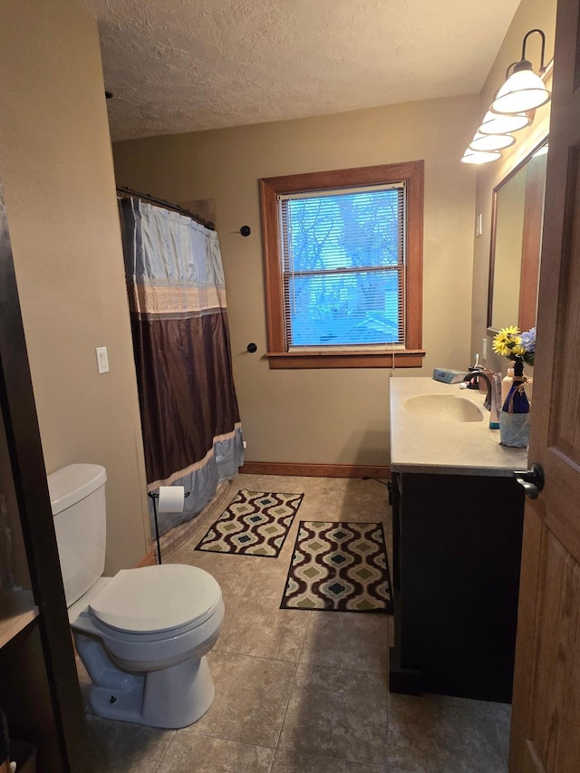 full bath with a textured ceiling, toilet, baseboards, curtained shower, and vanity