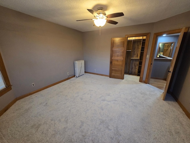 unfurnished bedroom featuring light carpet, a textured ceiling, and baseboards
