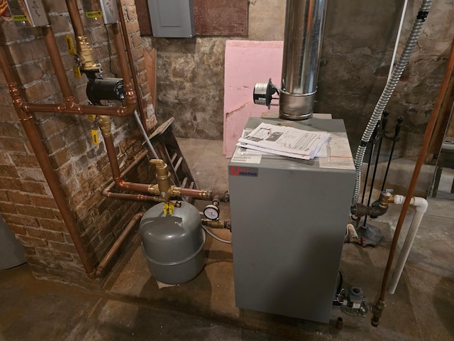 utility room featuring a heating unit and electric panel