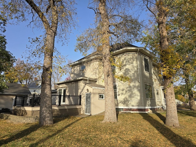 view of property exterior featuring a lawn and a deck