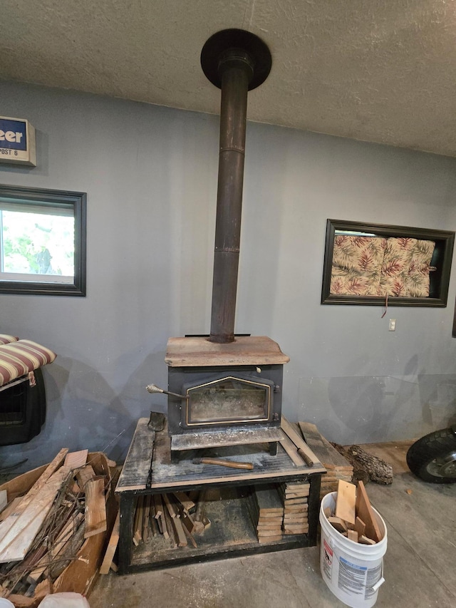 interior details featuring concrete flooring, a textured ceiling, and a wood stove