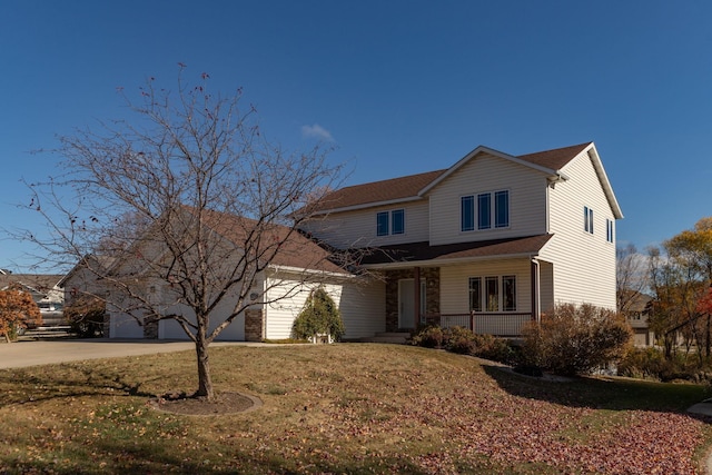 front facade featuring a porch, a front lawn, and a garage