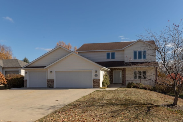 view of property with a front yard, covered porch, and a garage