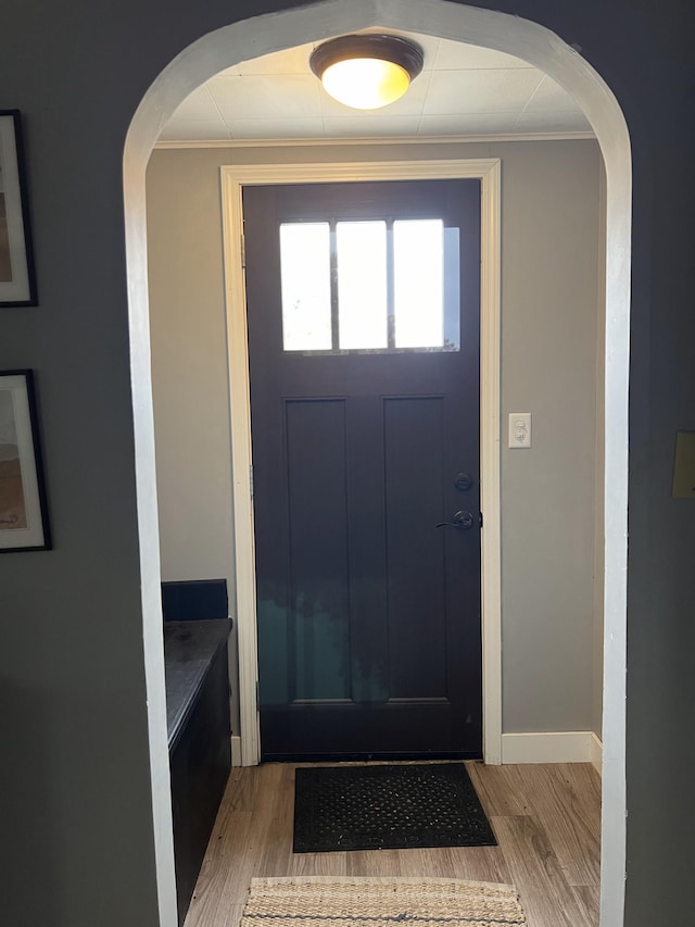 foyer with light hardwood / wood-style floors and ornamental molding