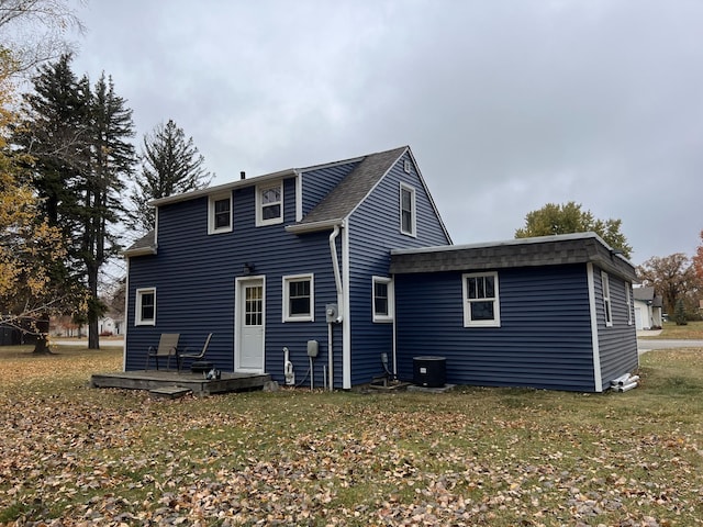 rear view of property with a yard, a deck, and cooling unit