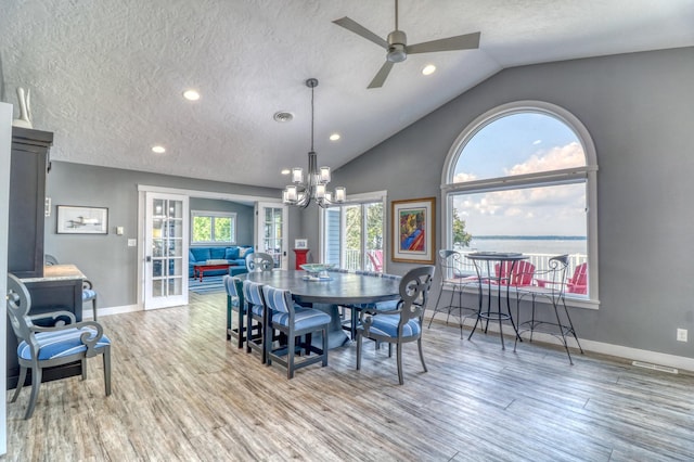 dining room featuring vaulted ceiling, wood-type flooring, and plenty of natural light