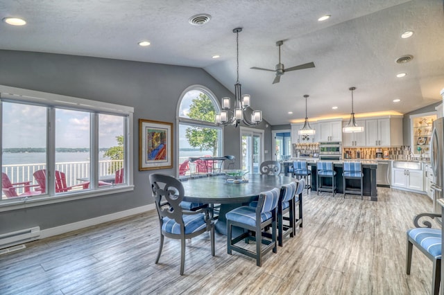 dining area with a healthy amount of sunlight, a water view, and light wood-type flooring