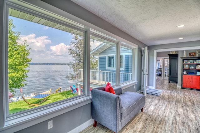 sunroom featuring a water view