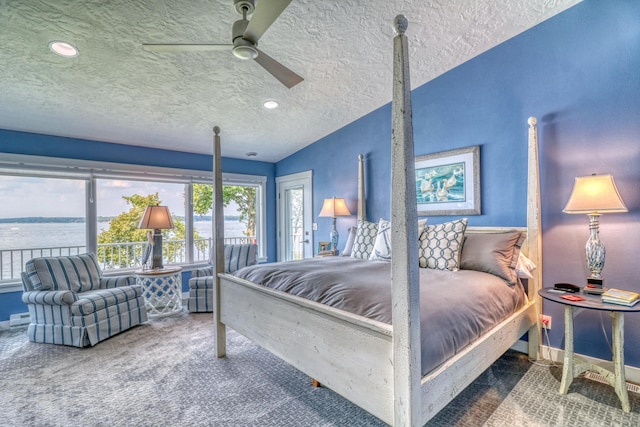 bedroom featuring a textured ceiling, carpet floors, ceiling fan, lofted ceiling, and a water view