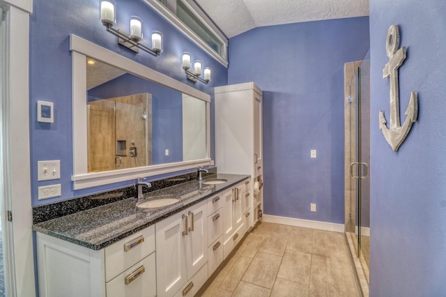 bathroom featuring a textured ceiling, a shower with shower door, lofted ceiling, vanity, and tile patterned flooring