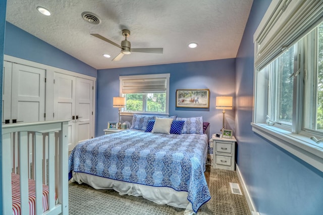 bedroom with ceiling fan, a textured ceiling, vaulted ceiling, and light colored carpet