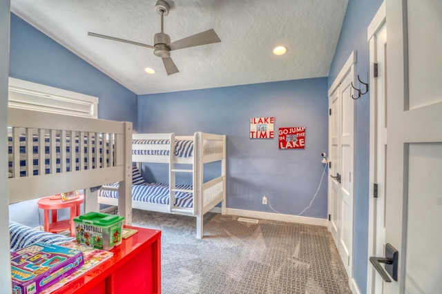 bedroom with dark carpet, lofted ceiling, a textured ceiling, and ceiling fan