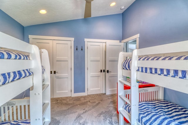 bedroom featuring lofted ceiling, carpet, and a textured ceiling