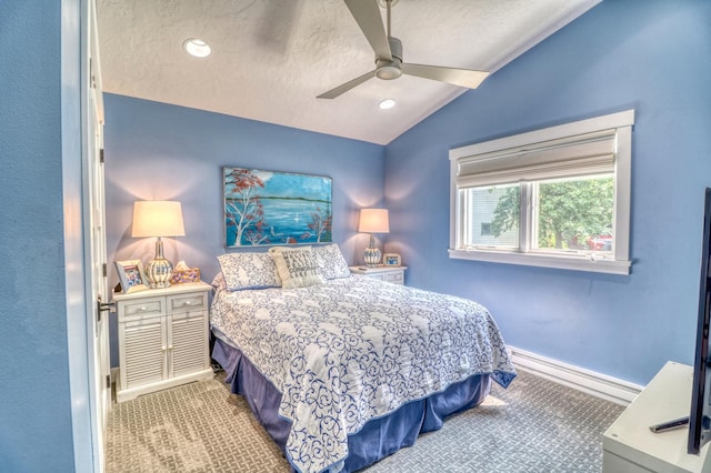 carpeted bedroom featuring lofted ceiling, a textured ceiling, and ceiling fan