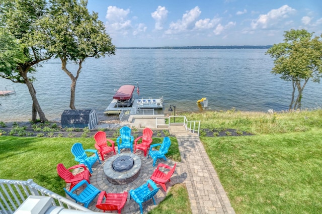 water view with an outdoor fire pit and a boat dock