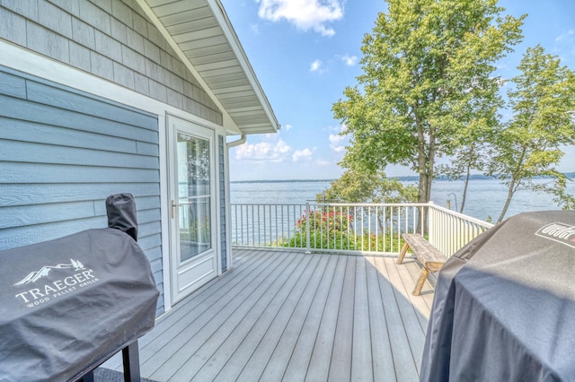 wooden deck featuring area for grilling and a water view