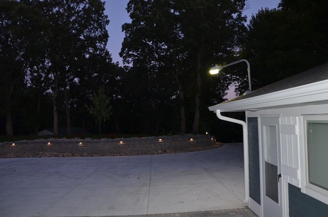 pool at dusk featuring a patio