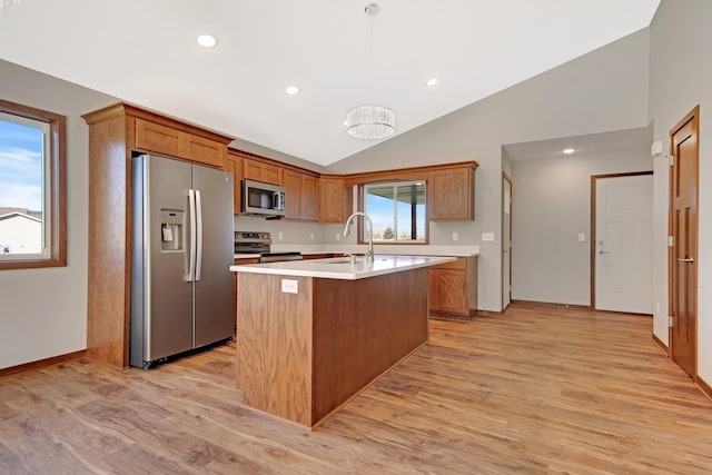 kitchen featuring light hardwood / wood-style flooring, lofted ceiling, a kitchen island with sink, and stainless steel appliances