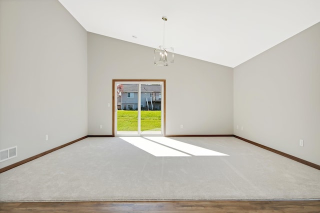 spare room with high vaulted ceiling, a notable chandelier, and wood-type flooring