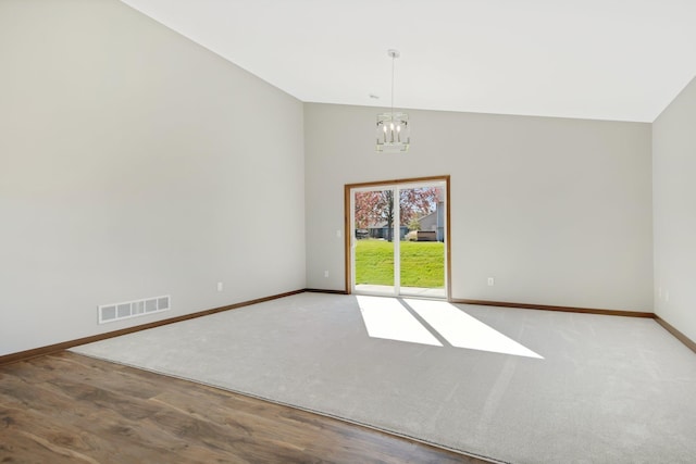 unfurnished room with light hardwood / wood-style flooring, lofted ceiling, and an inviting chandelier