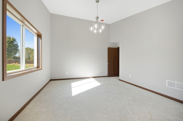 empty room featuring an inviting chandelier and carpet flooring