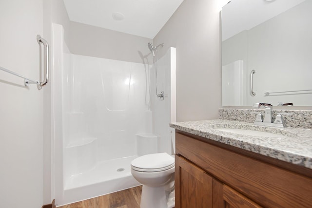 bathroom featuring toilet, hardwood / wood-style floors, vanity, and a shower