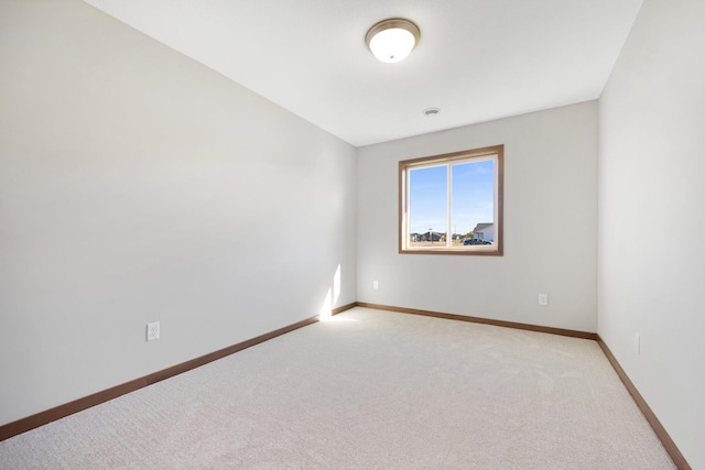 carpeted spare room with vaulted ceiling