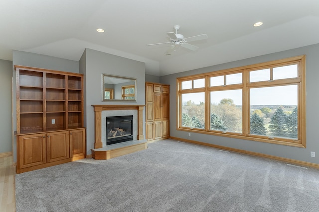 unfurnished living room featuring lofted ceiling, light carpet, and ceiling fan