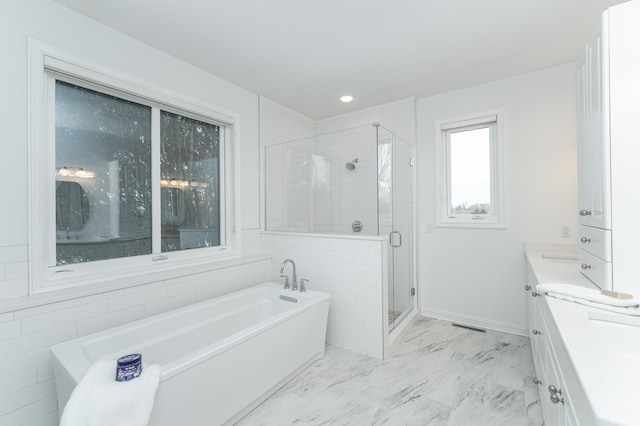 bathroom featuring vanity and independent shower and bath