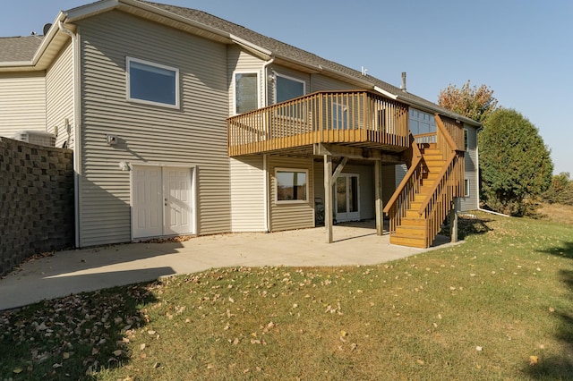 back of house featuring a wooden deck, a lawn, and a patio area